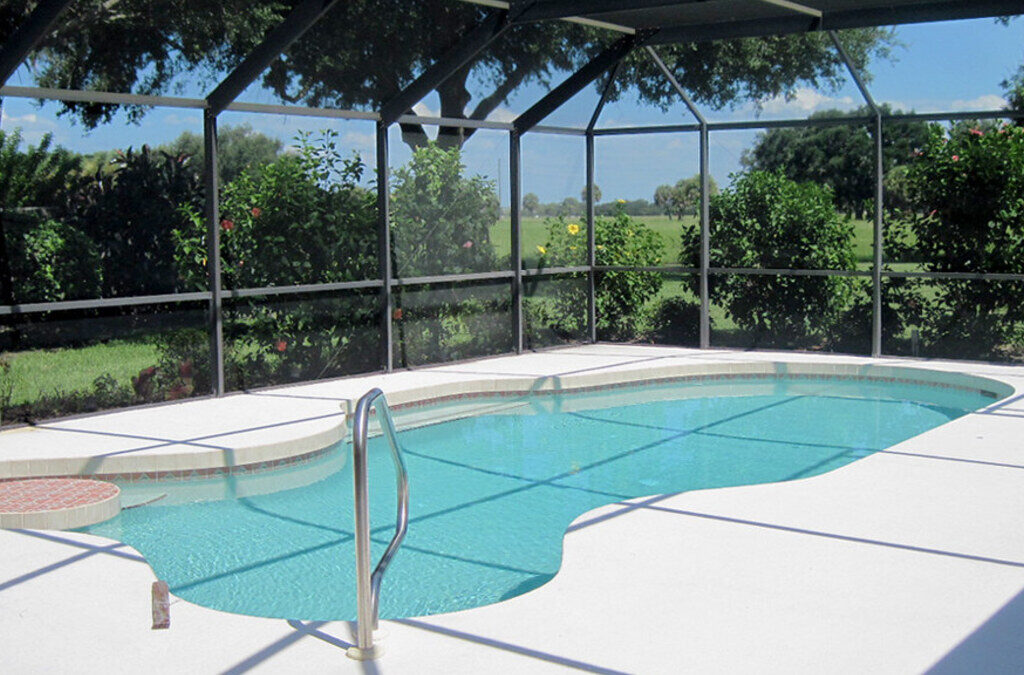 Screened pool cage enclosure over a backyard pool at a Central Florida home